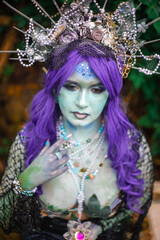 fabulous dark mermaid with blue skin in the forest close up