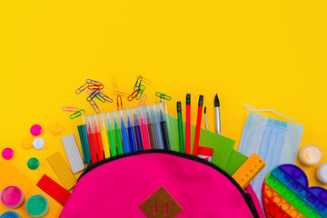 Obraz premium Back to school. Bright colorful school supplies and backpack for school or college on a yellow background.Stationery for school children's studies. Greeting card or banner for sale. layout
