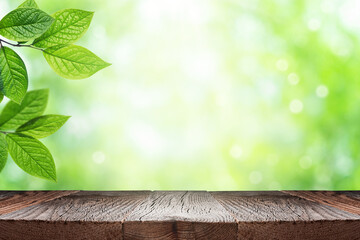 Empty wooden table top and green leaves of plant over blurred nature background. Summer background...