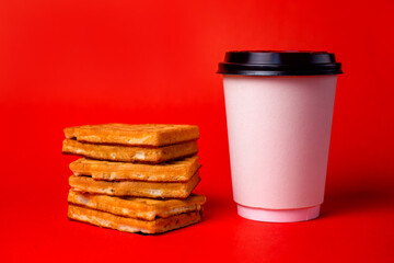 white coffee cup with waffles on red background