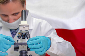 Female biochemist looking through a microscope against Poland flag background. Medical technology...