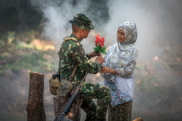 Girl villager give flowers to soldier to encourage fighting and protecting the border of country.