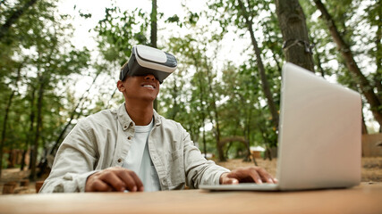 Smiling young african american man in virtual reality glasses