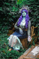 fabulous dark mermaid with blue skin in the forest close up