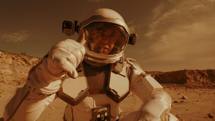 Male astronaut recording video on Mars