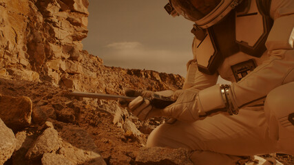 Unrecognizable astronaut analyzing soil of Mars - obrazy, fototapety, plakaty