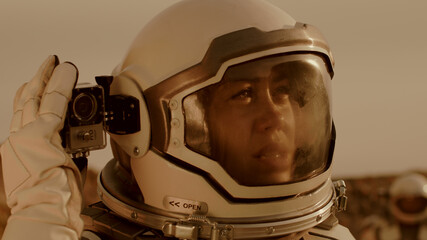 Female astronaut shooting terrain of Mars © Framestock