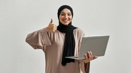 Young arabian woman in hijab showing thumb up
