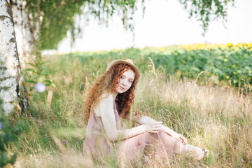 Red hair young girl in the field of summer