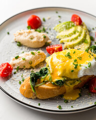 Fototapeta na wymiar Closeup on eggs benedict breakfast with chicken pate and avocado