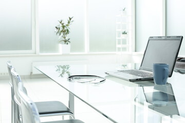 Laptop stethoscope coffee cup phone and day planner on glass table in office space