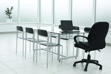 Laptop on glass table in spacious office space