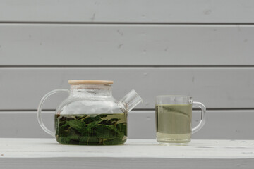 Glass teapot with a drink. Fresh mint.