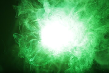 Artificial magic smoke in green light on black background