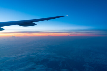 Fototapeta na wymiar 飛行機の窓から見える朝焼け
