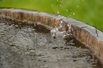 rain is falling in a wooden barrel full of water in the garden
