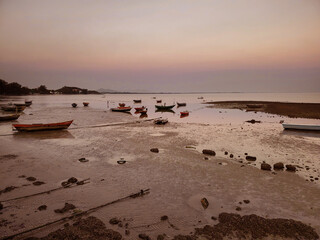 Fall of sea levels at sunset with fish boats tides