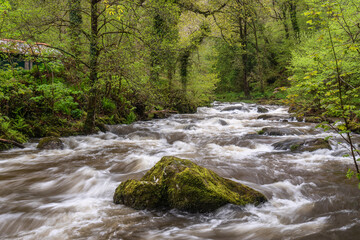 Stunning Spring landscape image of Watrersmeet in Devon England where two rivers meet to form one large powerful river