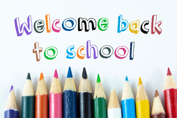 Text Welcome back to school on color pencil background
