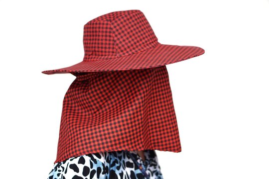 Woman wears red hat with face cover. Concept woman fashion. Protection from sun burn when going out.