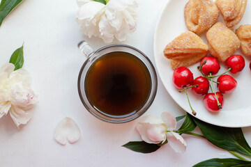 coffee, homemade cookies and cherry with peony flowers