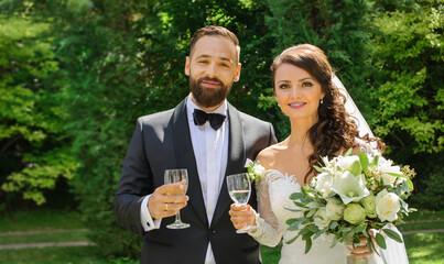 a happy bride and groom with wine glasses in hand