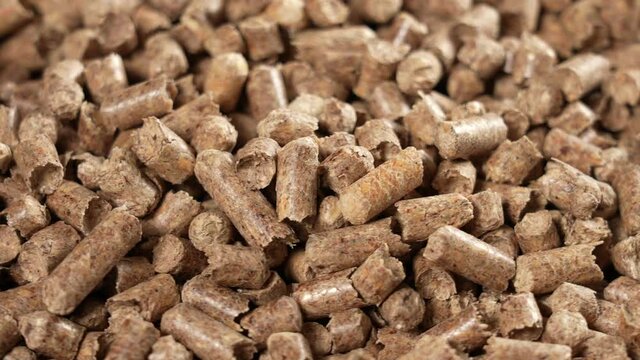 Close-up view 4k stock video footage of brown organic wooden granules (pellets) isolated