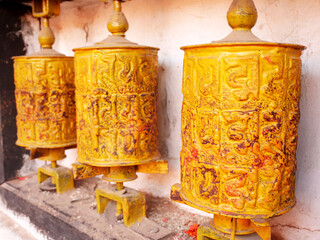 Metal brass prayer wheels on wall of Hariti shrine or Ajima Hindu Temple at Swayambhunath pagoda or Monkey Temple for nepali people and foreign traveler rotate respect praying in Kathmandu, Nepal