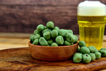 wasabi coated nuts with a wooden background