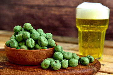 wasabi coated nuts with a wooden background