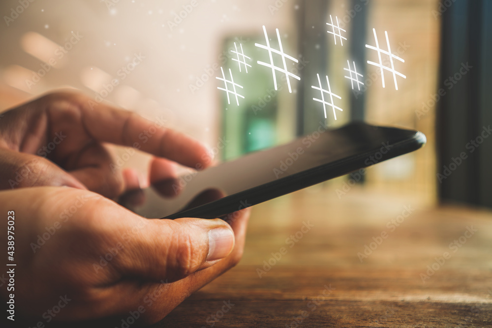 Poster man's hand is playing social media idea a word or phrase preceded by a hashtag (#) and used to ident
