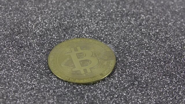 Bitcoin cryptocurrency falls on silver sequins.