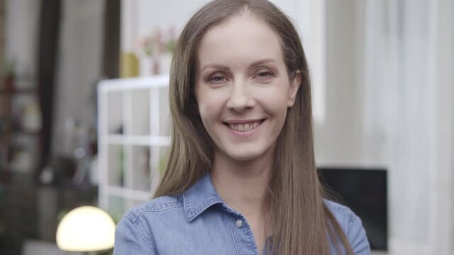 Portrait of happy white young woman at home, smiling.