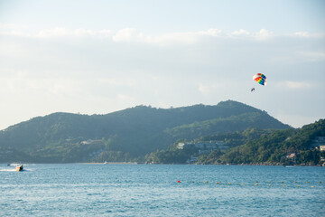 Parasailing over sea with beautiful blue sky background at Patong beach, Phuket,Thailand. soft socus.