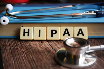 Wooden block written with HIPAA ( Health Insurance Portability and Accountability Act ) inscription...