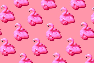 Inflatable pink flamingo pool toy pattern on pink background. Creative minimal summer concept
