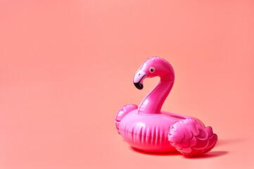 Inflatable pink flamingo pool toy on pink background. Creative minimal concept