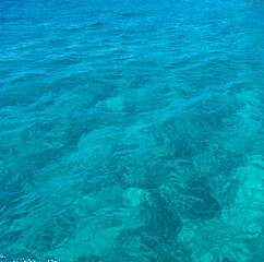 Fototapeta na wymiar Sea surface turquoise blue color background. Calm crystal clear water with small ripples