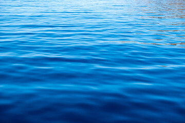 Sea water surface calm with small ripples. Still ocean, deep blue color background,