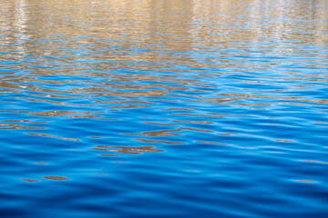 Sea water surface calm with small ripples. Still ocean, deep blue color background,