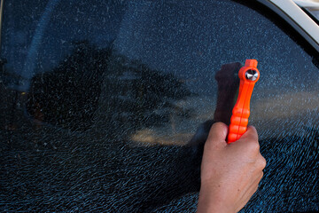 Emergency Hammer and cracked car glass Safety hammer concept