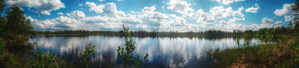 Fototapeta premium Panorama of small Swedish lake with heavy clouds and sunlight