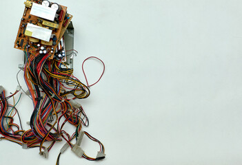 Disassembled power supply of a stationary personal computer on an isolated background. Electronics repair. Free space for inserting text.