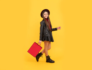 happy teen girl in hat and leather clothes hold shopping bag, fashion