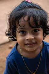 Close-up portrait of a  beautiful little girl looking at camera with curious expression