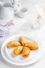 curry puff or kari pap is a snack of Maritime Southeast Asian origin.  It is a small pie consisting of curry with chicken and potatoes in a deep-fried or baked pastry shell. 