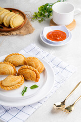 curry puff or kari pap is a snack of Maritime Southeast Asian origin.  It is a small pie consisting of curry with chicken and potatoes in a deep-fried or baked pastry shell. 