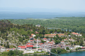 Fototapeta na wymiar Aerial view of city Shkoder, mosque at river near big lake and castel hill