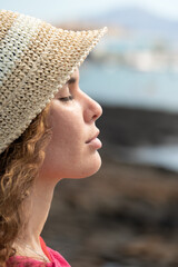 Profile portrait close up of a young hispanic woman with closed eyes breathing deep fresh air and...