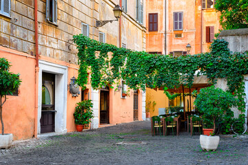 Fototapeta na wymiar Cozy old street in Trastevere in Rome, Italy. Trastevere is rione of Rome, on west bank of Tiber in Rome. Architecture and landmark of Rome